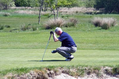 man looking at golf ball