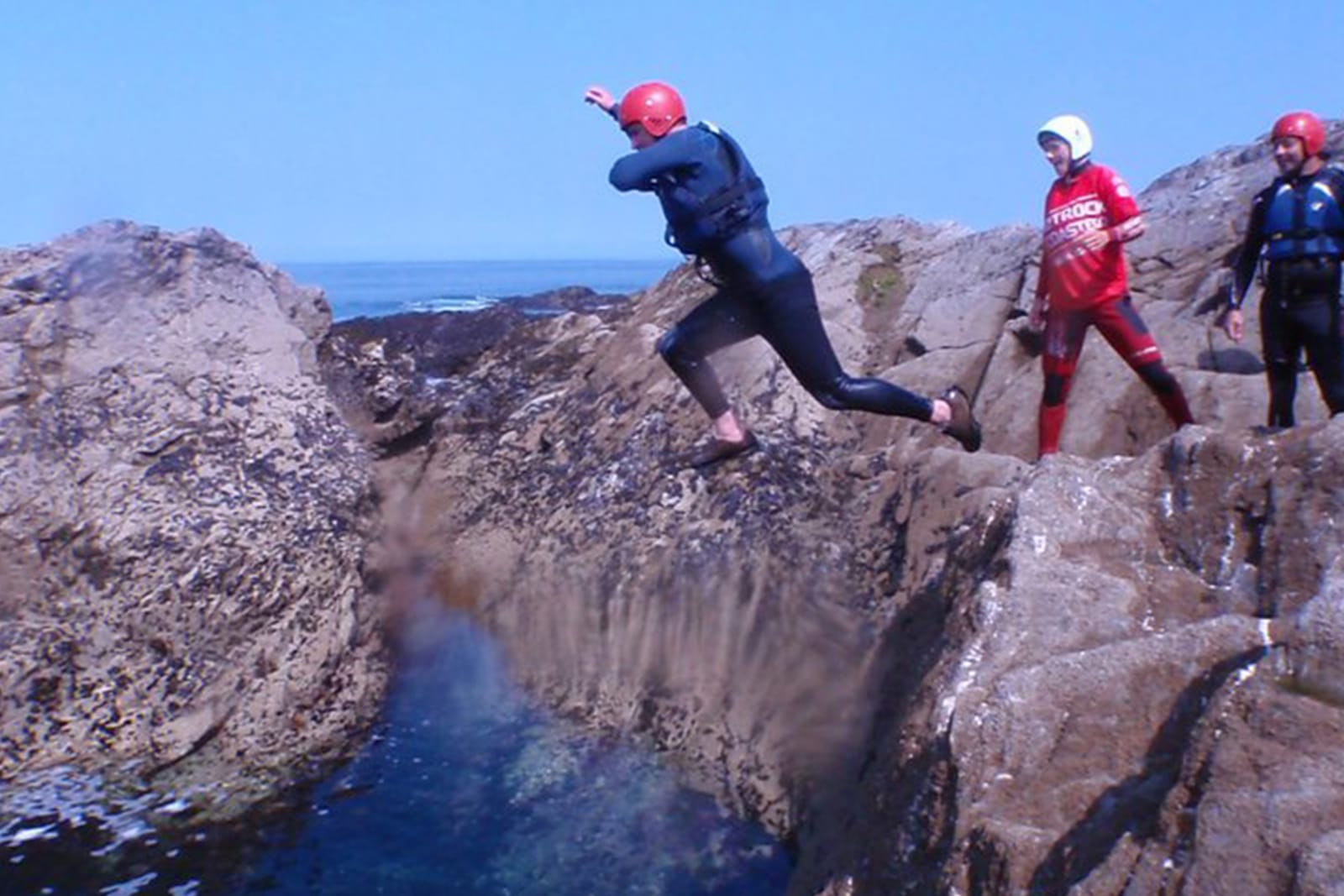 person jumping into the sea, coasteering