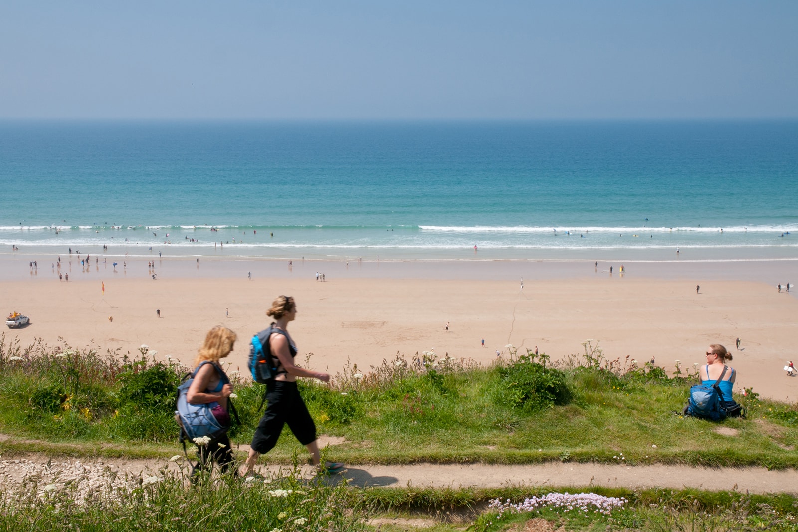 walkers on beach path near Watergate Bay