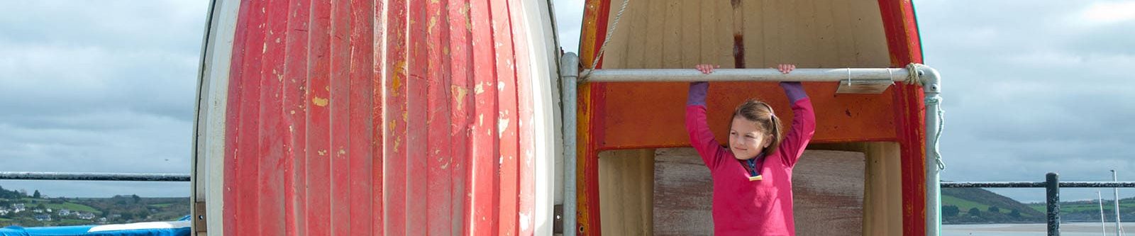 girl in front of a red boat