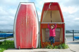 girl in front of a red boat