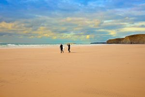 surfers walking to sea