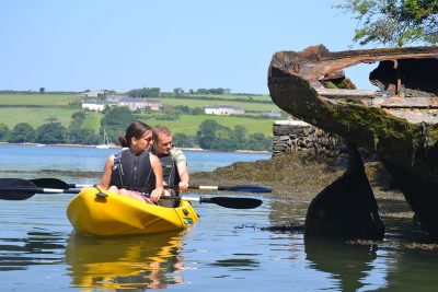 people looking at wreck from kayak