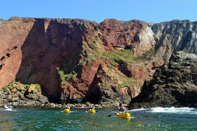 kayakers by cliffs