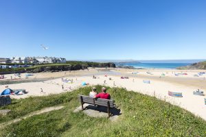 Two people on bench overlooking Trevone beach