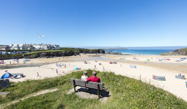 Two people on bench overlooking Trevone beach