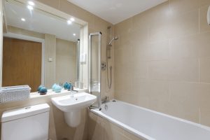 Bath with overhead shower and basin