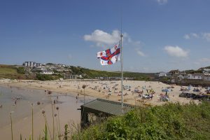 RNLI flag and bathers enjoying the beach and sea