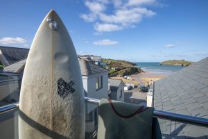 Surfboard and wetsuit on balcony with sea view