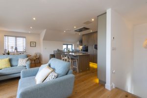 Blue couches, dining area, kitchen and breakfast bar