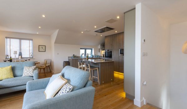 Blue couches, dining area, kitchen and breakfast bar