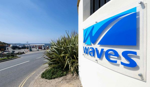 Waves Apartments sign and beach view