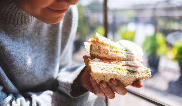Person holding freshly made sandwich