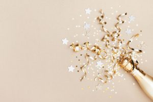 golden champagne bottle, confetti stars and party streamers