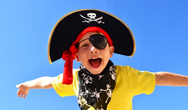 Child dressed as a pirate against a blue sky background