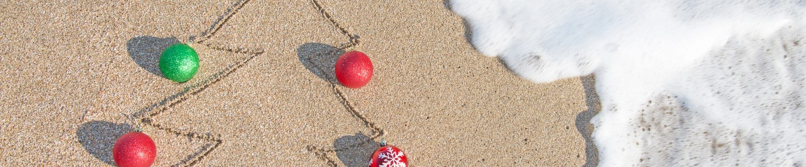Christmas tree drawn in sand with real baubles