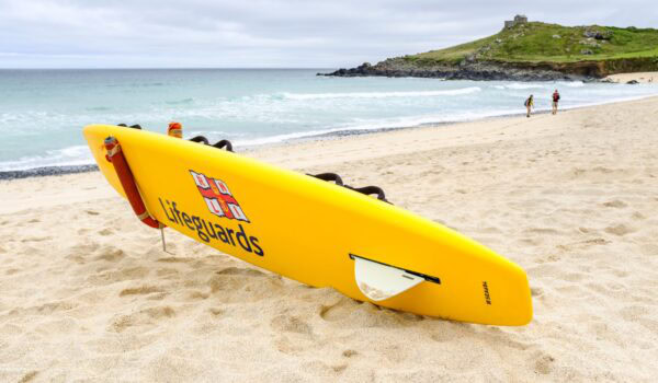 RNLI Lifeguards yellow surfboard on Porthmeor beach, Cornwall.